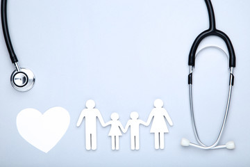 Family figures with white heart and stethoscope on grey background