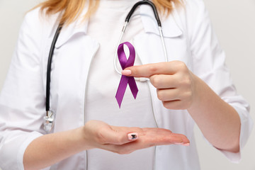 Lymphoma concept. Purple ribbon in the hand isolated