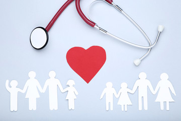 Family figures with red heart and stethoscope on grey background