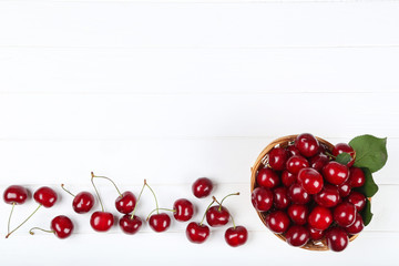 Sweet cherries in basket on white wooden table