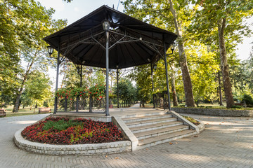 Autumn story: a large forged gazebo with steps in the center of