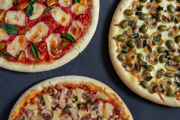 Three different pizza on a black background