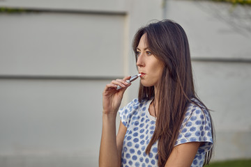 Electronic cigarette technology. Tobacco IQOS system. Close-up of a girl smoking an electric hybrid...