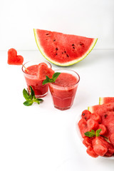 Watermelon smoothie fresh juice with mint, pieces of watermelon in the shape of hearts and slices of watermelon. Healthy drinks in glasses on a white background.