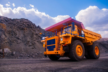A large mining dump truck transports ore in a quarry