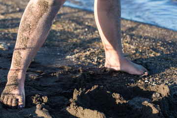 Childs sandy feet and legs dirty on the beach