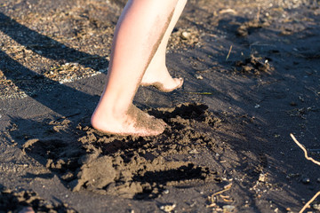Childs sandy feet and legs dirty on the beach