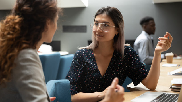Asian businesswoman communicating with female colleague in office