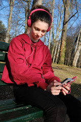 Obraz premium smiling teenager girl listen to music on a mobile