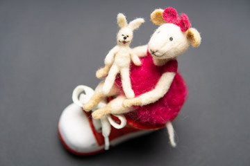 Close-up of felted wool toy. Hobbies, handmade, craft, leisure, learning, mouse, creativity, design concept, hare. Beautiful figure with a sneaker