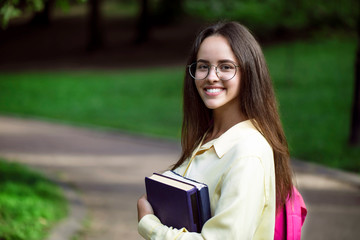 Portrait of young enthusiastic student girl posing on her way to classes
