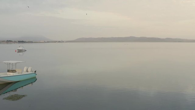 View flying near boats in calm waters in the morning. Sunrise at Paracas Coast, Peru
