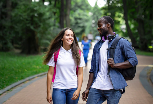 A pair of multicultural students enjoying their walk through the campus park