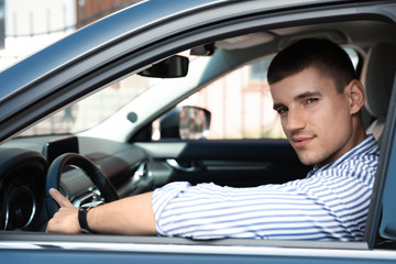Fototapeta na wymiar Attractive young man in modern luxury car