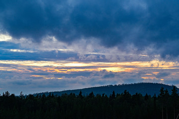 tree line and sunset on a cloudy sky