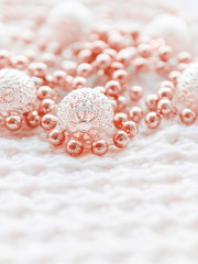 Christmas and New Year decorations on white knitted background. Metal light bulbs with delicate pattern, light red beads.