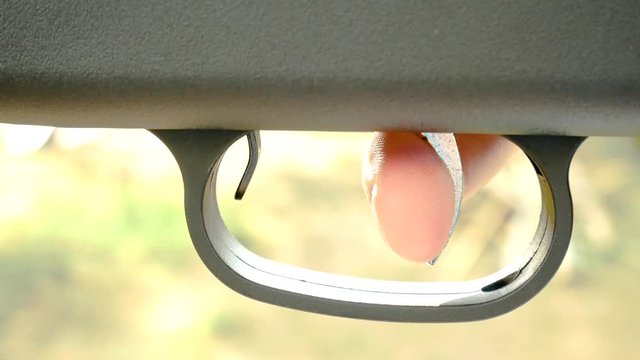 Close up of human male hand pushing gun trigger and shooting with gun. Extreme militry team sport