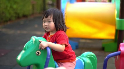 A cute young Asian Child baby girl kid age 2 plays in playground ,Concept photo childhood 