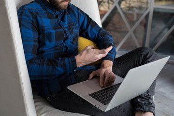 Man business planning expert reading text message on mobile phone during work on laptop computer....
