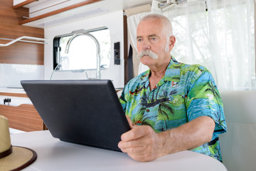 senior man using laptop in motorhome