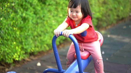 A cute young Asian Child baby girl kid age 2 plays in playground ,Concept photo childhood 