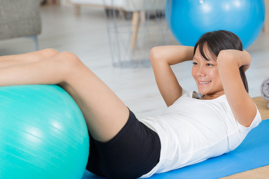 young woman does various exercises with a ball