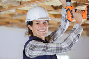 portrait of young pretty woman working on ceiling