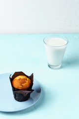 Milk and muffin over blue backgroound