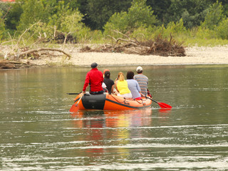 A group of tourists rafting on a mountain river on a pontoon. Tourist routes of Transcarpathia in Ukraine. Rafting on the Tissa River. Safety on the water. Lifeboat and the man behind the bot - MOB.