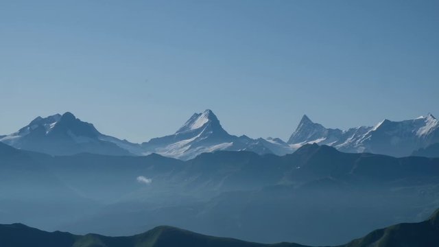 Panoramic view from left to right of the bernese alps. The mountains Eiger, Moench, Jungfrau, Finsteraarhorn, and Augstmatthorn during a summer day, no clouds, 4k