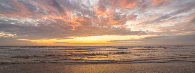 Panorama of colorful clouds over sea at sunset