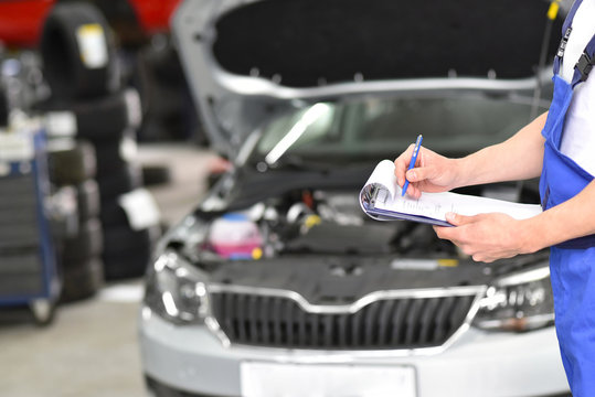 service and inspection of a car in a workshop - mechanic inspects the technology of a vehicle for function and safety