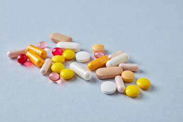 Vitamins and supplements on bright paper background. Concept for a healthy dietary supplementation. Close up. Copy space. 