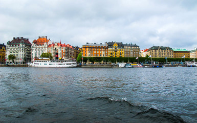 Panoramic view from the tourist boat on the pier with boats and the beautiful buildings of...