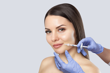 There is a woman, who is making the Lips augmentation procedure  in a beauty salon.Cosmetology skin...