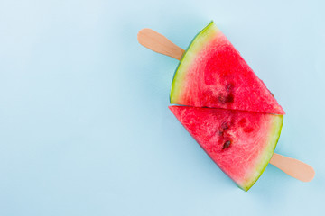 Watermelon slice popsicles on a turquoise background. Fresh watermelon on wooden sticks. Summer concept