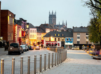 Cars parked in a row at Kilkennys town and castles view in  the background, Kilkenny, Ireland. - obrazy, fototapety, plakaty