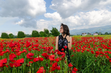 Obraz na płótnie Canvas Beautiful girl in poppy field.