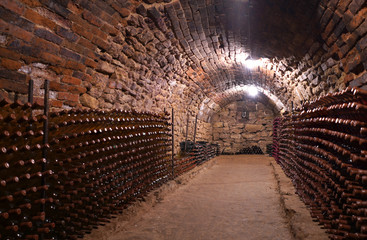 Old wine cellar with rose wine. Bottles of expensive wine in the cellar