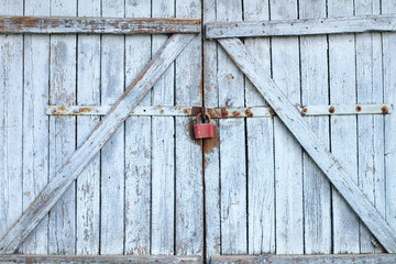 Old gray wooden plank gate with a padlock.