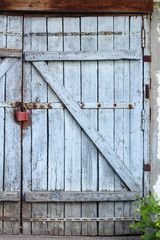 Old gray wooden plank gate with a padlock.