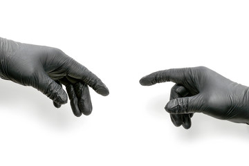 Two hands in black rubber gloves, one pointing to the other. Allusion to the picture Creation of Adam by Michelangelo Buonarroti, isolated on white background.