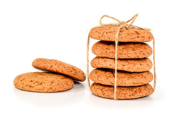 Homemade cookies. Five sweet cookie made from oatmeal flour, stacked and tied with linen rope in rustic style and two next. Tasty biscuit in high resolution closeup isolated on white background.