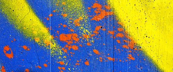 Paint on the wall in red, blue and yellow. Grunge background