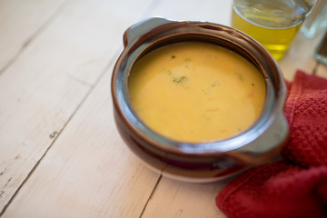 broccoli cheese soup served in a brown bowl 