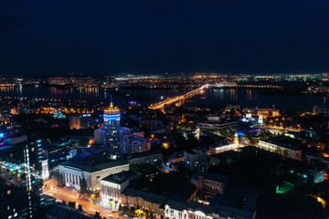 Fototapeta na wymiar Night City Voronezh downtown or center panorama from above with illuminated road intersection, car traffic, modern business and residential buildings