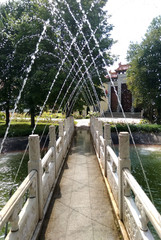 Chinese-style marble bridge under the jets of a beautiful fountain
