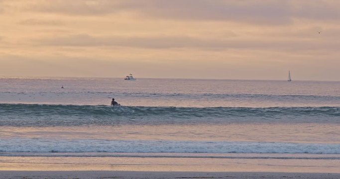 Surfer Paddling Out at Sunset