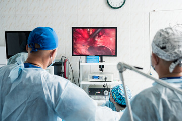 Process of gynecological surgery operation using laparoscopic equipment. Group of surgeons in...