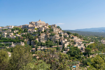 Fototapeta premium Gordes piękna stara wioska z pastelowymi budynkami na wzgórzu otoczonym górami w Vaucluse w Prowansji, Francja